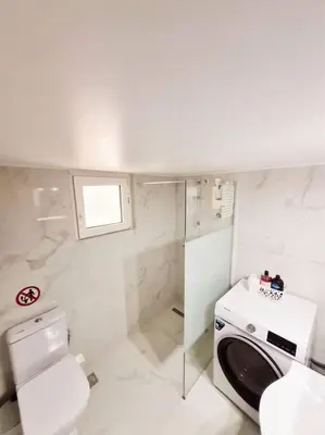 a white bathroom with a toilet and a sink at Lovely 2-Bedroom 4th Floor House Large Patio in Athens