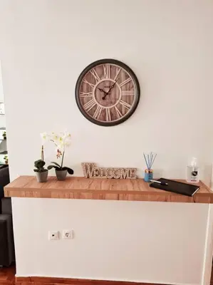 a clock on a wall above a counter with plants at Lovely 2-Bedroom 4th Floor House Large Patio in Athens