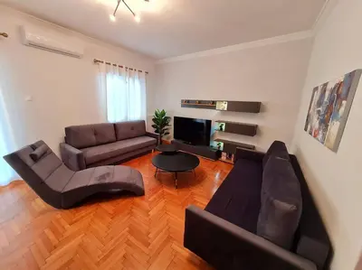 a living room with a couch and a table at Lovely 2-Bedroom 4th Floor House Large Patio in Athens