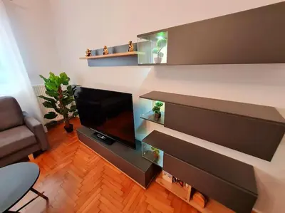 a living room with a flat screen tv and shelves at Lovely 2-Bedroom 4th Floor House Large Patio in Athens