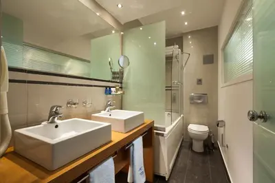a bathroom with a white sink and a toilet at Tropical Hotel in Athens