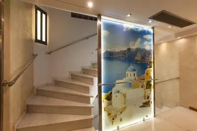 a wall mural of santorini in a hallway with stairs at Tropical Hotel in Athens