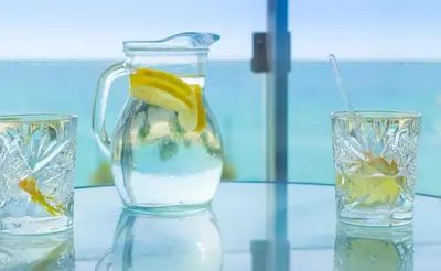 two glasses of water with a pitcher and a lemon slice at Tropical Hotel in Athens