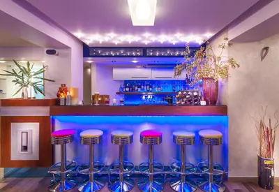 a bar with pink and blue bar stools at Tropical Hotel in Athens