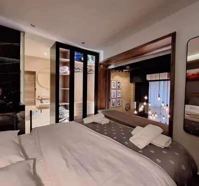 a bedroom with a large bed and a bathroom at The Athens Loft with private gym and billiards in Athens