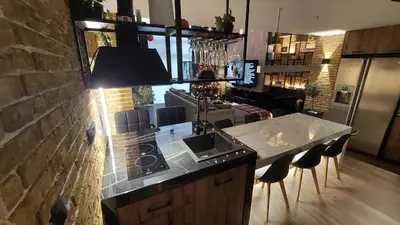 a kitchen with a sink and a counter with chairs at The Athens Loft with private gym and billiards in Athens