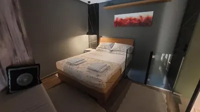 a small bedroom with a bed with two towels on it at The Athens Loft with private gym and billiards in Athens