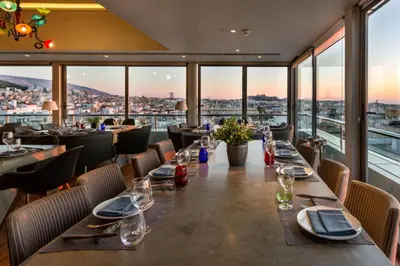 a long table in a restaurant with a view at Radisson Blu Park Hotel Athens in Athens
