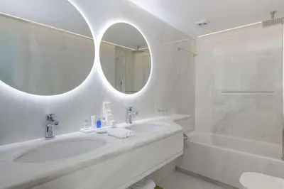 a bathroom with a sink and a tub and a mirror at Radisson Blu Park Hotel Athens in Athens
