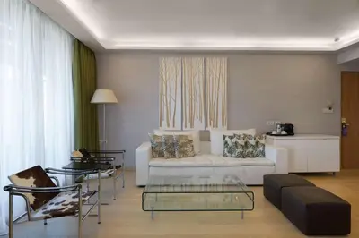 a living room with a white couch and chairs at Radisson Blu Park Hotel Athens in Athens