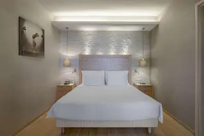 a bedroom with a large white bed with two night stands at Radisson Blu Park Hotel Athens in Athens