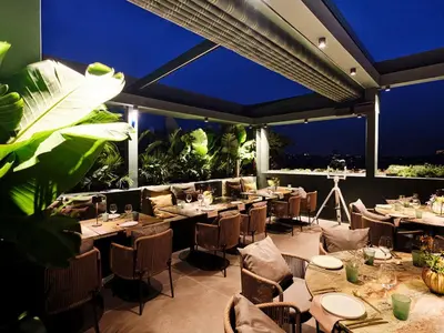 a restaurant with tables and chairs on a patio at Radisson Blu Park Hotel Athens in Athens