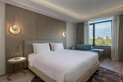 a hotel room with a large bed and a window at Radisson Blu Park Hotel Athens in Athens