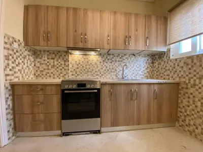a kitchen with wooden cabinets and a stove top oven at Spacious 3 BR Apartment in Vibrant Neighbourhood in Athens
