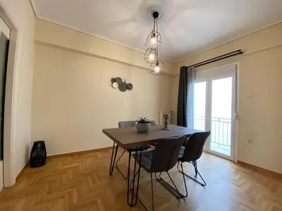 a dining room with a table and chairs and a window at Spacious 3 BR Apartment in Vibrant Neighbourhood in Athens