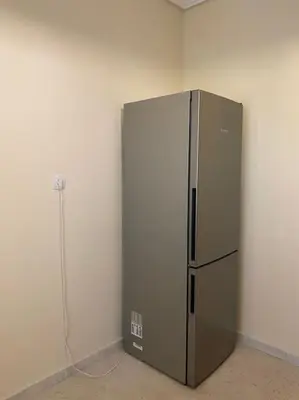 a stainless steel refrigerator in a corner of a room at Spacious 3 BR Apartment in Vibrant Neighbourhood in Athens