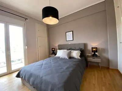 a bedroom with a large bed and a large window at Spacious 3 BR Apartment in Vibrant Neighbourhood in Athens
