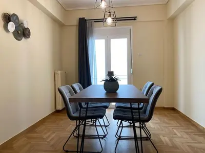a dining room table with chairs and a potted plant on it at Spacious 3 BR Apartment in Vibrant Neighbourhood in Athens