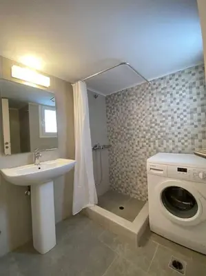 a bathroom with a washing machine and a sink at Spacious 3 BR Apartment in Vibrant Neighbourhood in Athens