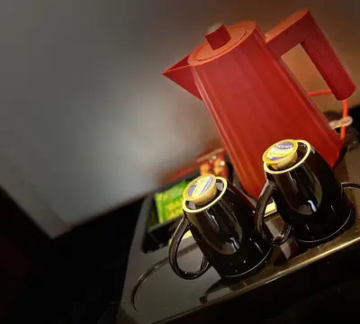 two coffee mugs on a table with a red lamp at Triton Hotel Piraeus in Piraeus