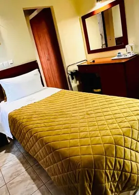 a hotel room with a large bed with a yellow blanket at Triton Hotel Piraeus in Piraeus