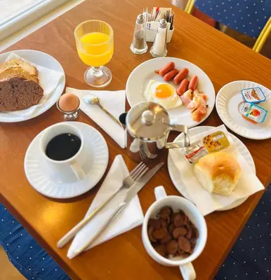 a table with breakfast foods and coffee on it at Triton Hotel Piraeus in Piraeus
