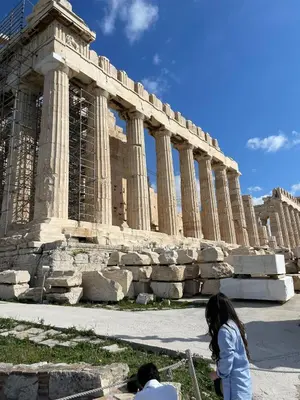 a couple of people standing in front of a temple at Acropolis selected apartment in Athens