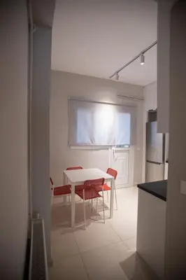 a kitchen with a white table and red chairs at Acropolis Vibes Apartments in Athens