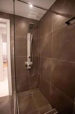 a shower with a glass door in a bathroom at Acropolis Vibes Apartments in Athens