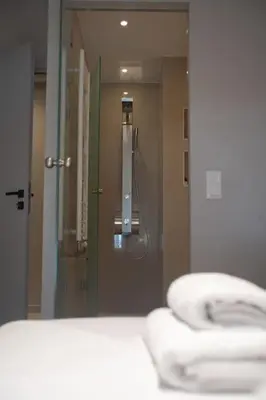 a bathroom mirror with towels in front of a shower at Acropolis Vibes Apartments in Athens