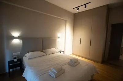 a bedroom with a white bed with towels on it at Acropolis Vibes Apartments in Athens