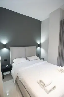 a bedroom with a large white bed with two towels on it at Acropolis Vibes Apartments in Athens