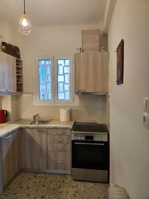 a kitchen with wooden cabinets and a stove top oven at F23 in Athens