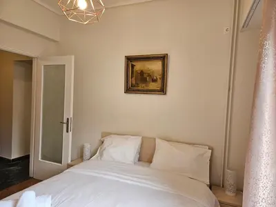 a bed with white sheets and a picture on the wall at F23 in Athens