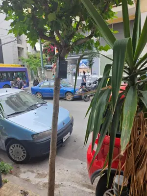 a couple of cars parked next to a tree at F23 in Athens