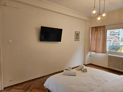a bedroom with a bed with a flat screen tv on the wall at F23 in Athens