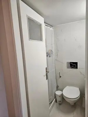 a white bathroom with a toilet and a shower at F23 in Athens