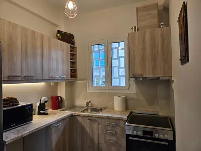 a kitchen with wooden cabinets and a stove top oven at F23 in Athens