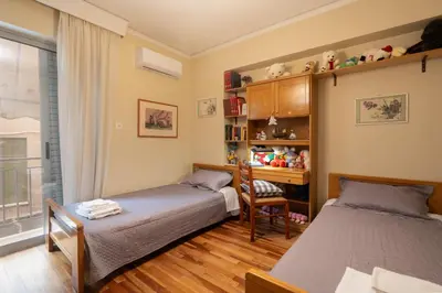a bedroom with two beds and a desk and a chair at 2 BR Apartment 5 minutes to Thissio Metro & Acropolis in Athens