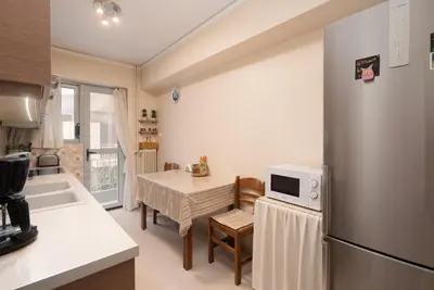 a kitchen with a table and a stainless steel refrigerator at 2 BR Apartment 5 minutes to Thissio Metro & Acropolis in Athens