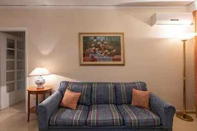 a living room with a couch and a painting on the wall at 2 BR Apartment 5 minutes to Thissio Metro & Acropolis in Athens