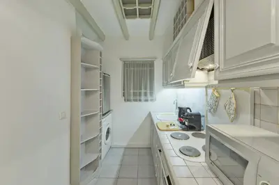 a kitchen with white cabinets and a stove top oven at Mavili Square Cozy Apt AC & Kitchen, near Metro in Athens