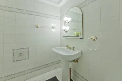 a white bathroom with a sink and a mirror at Mavili Square Cozy Apt AC & Kitchen, near Metro in Athens