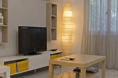 a living room with a tv and a table at Mavili Square Cozy Apt AC & Kitchen, near Metro in Athens