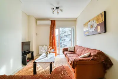 a living room with a couch and a tv at Escape with Style in this Chic 2BR Apartment! in Athens