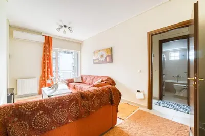 a living room with a couch and a bathroom at Escape with Style in this Chic 2BR Apartment! in Athens