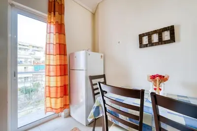 a kitchen with a refrigerator and a table and a window at Escape with Style in this Chic 2BR Apartment! in Athens