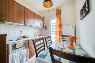 a kitchen with a table and a kitchen with a refrigerator at Escape with Style in this Chic 2BR Apartment! in Athens