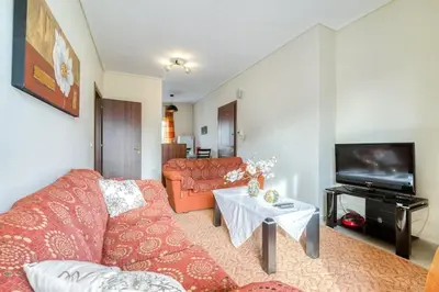 a living room with a red couch and a tv at Escape with Style in this Chic 2BR Apartment! in Athens