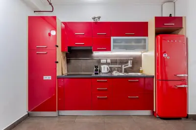 a red kitchen with a sink and a red refrigerator at Filopapou Pearl on Acropolis Hill in Athens